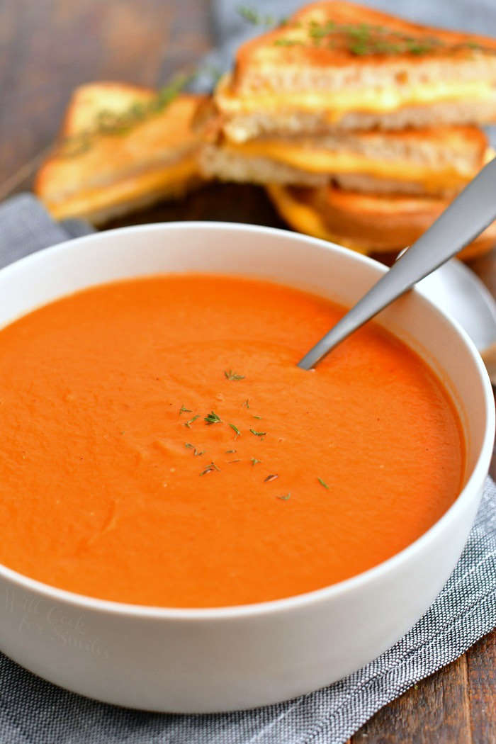 white bowl filled with homemade tomato soup made from scratch - spoon in the bowl