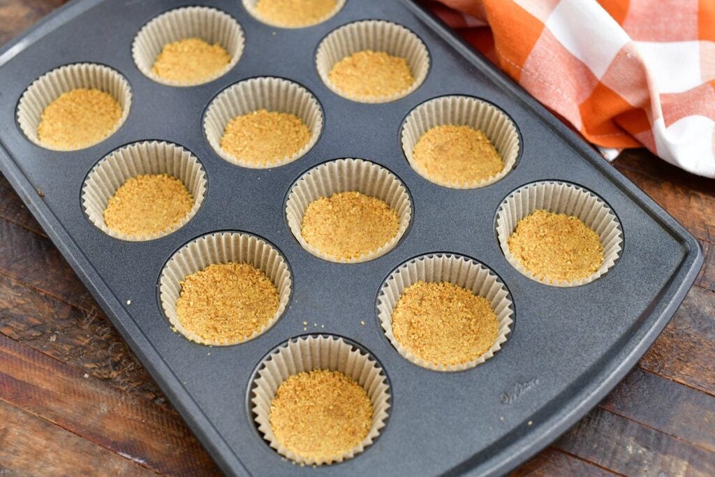 graham cracker crumb crusts in paper lined muffin pan