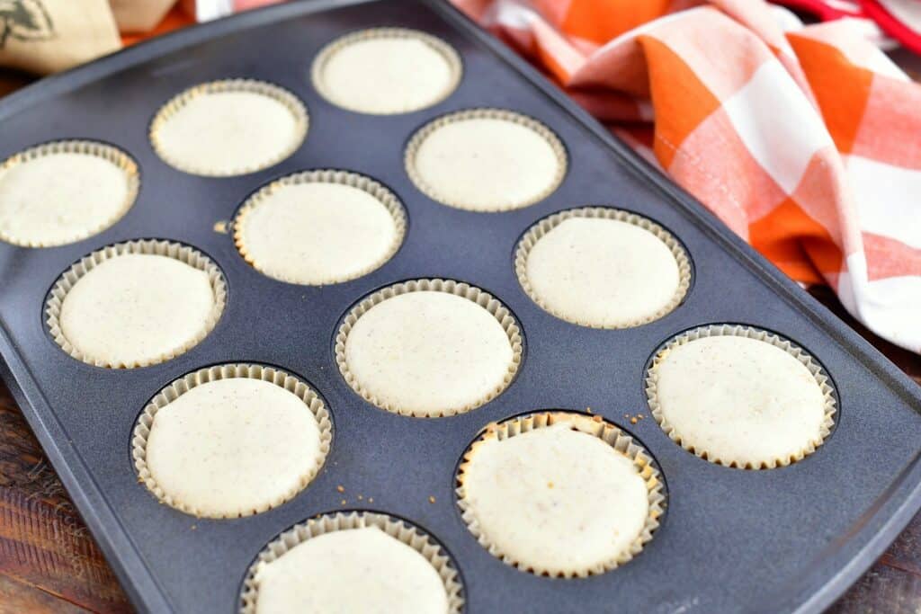 baked cheesecake batter in paper liners of 12-cup muffin pan