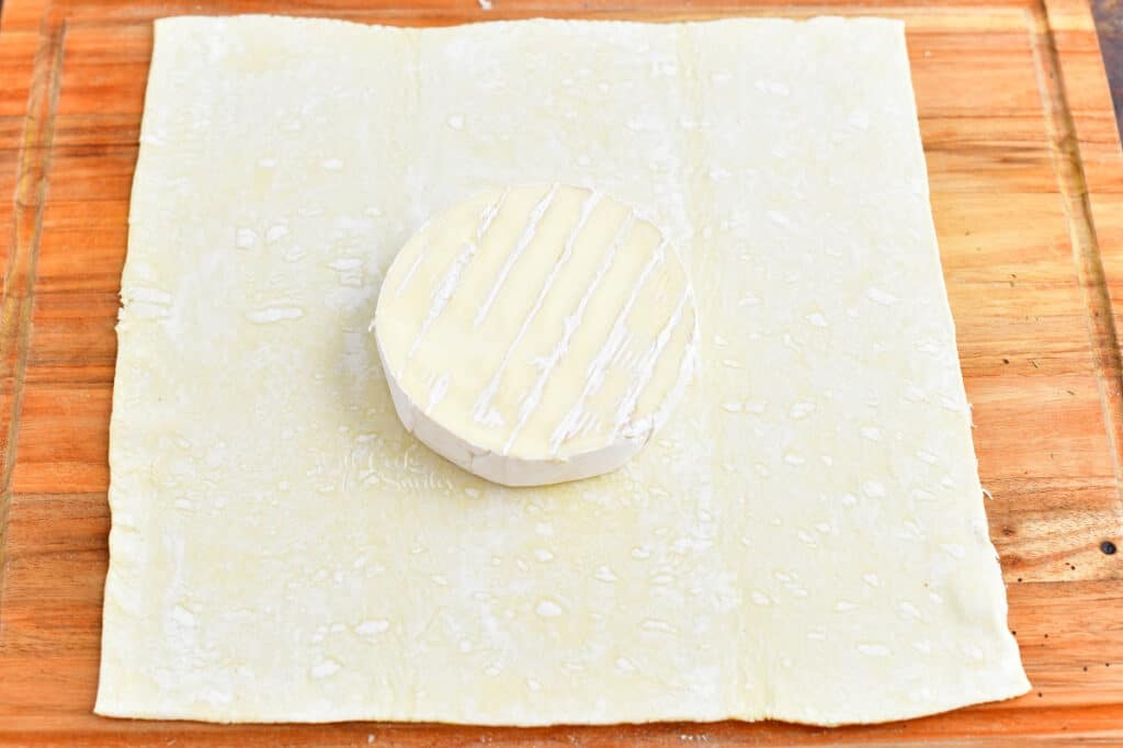 brie wheel on top of sheet of puff pastry