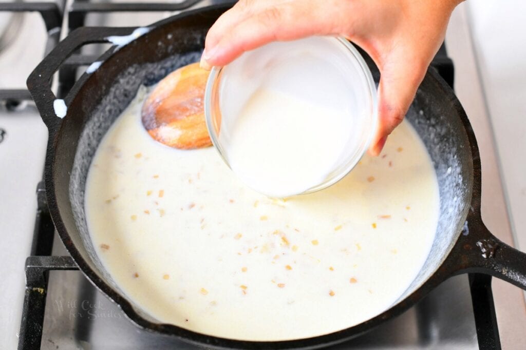 overhead image: pouring heavy cream into a cast iron skillet