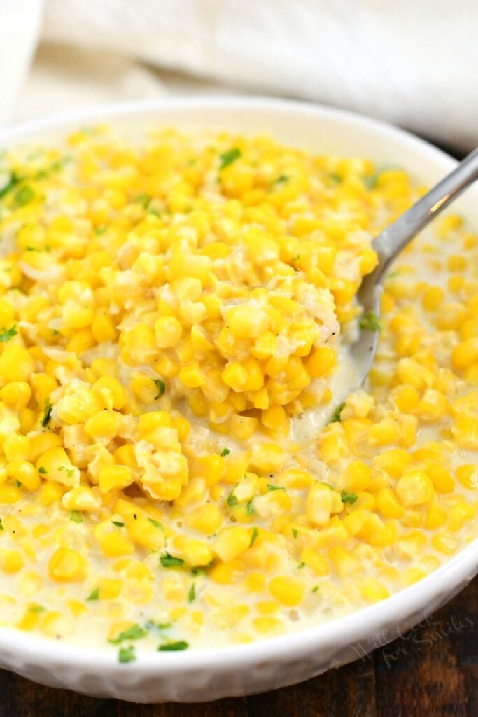 overhead closeup: spoonful of creamed corn in a bowl