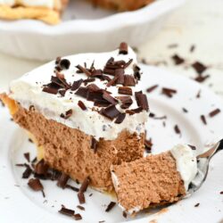 forkful of creamy chocolate pie topped with whipped cream and chocolate shavings