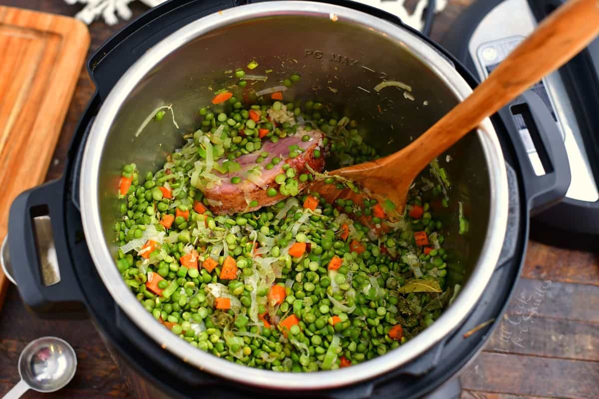 stirring the split peas, carrots, and leeks in an Instant Pot.