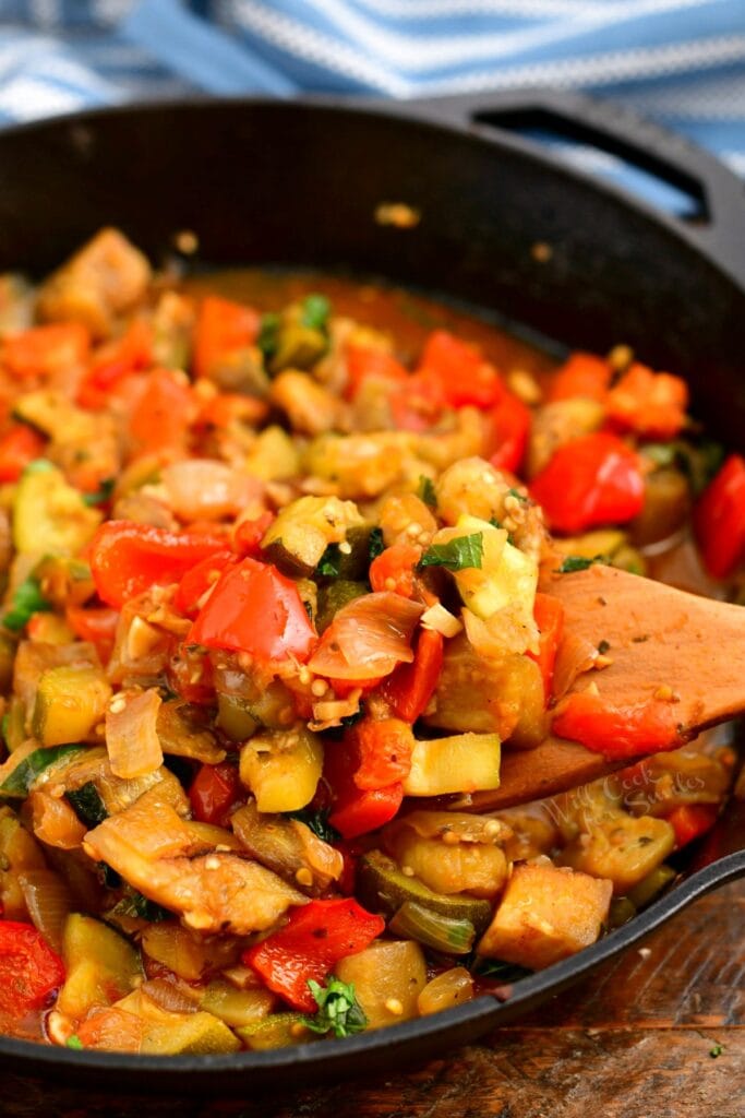 stirring homemade ratatouille in black skillet