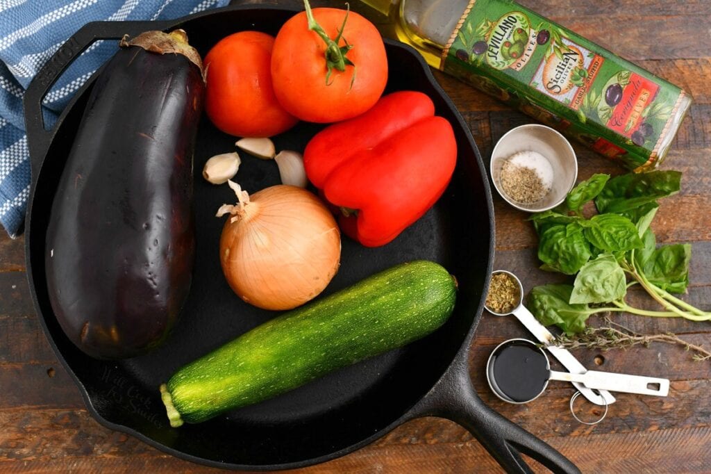 fresh eggplant, zucchini, onion, bell peppers, and tomatoes for a French stew recipe