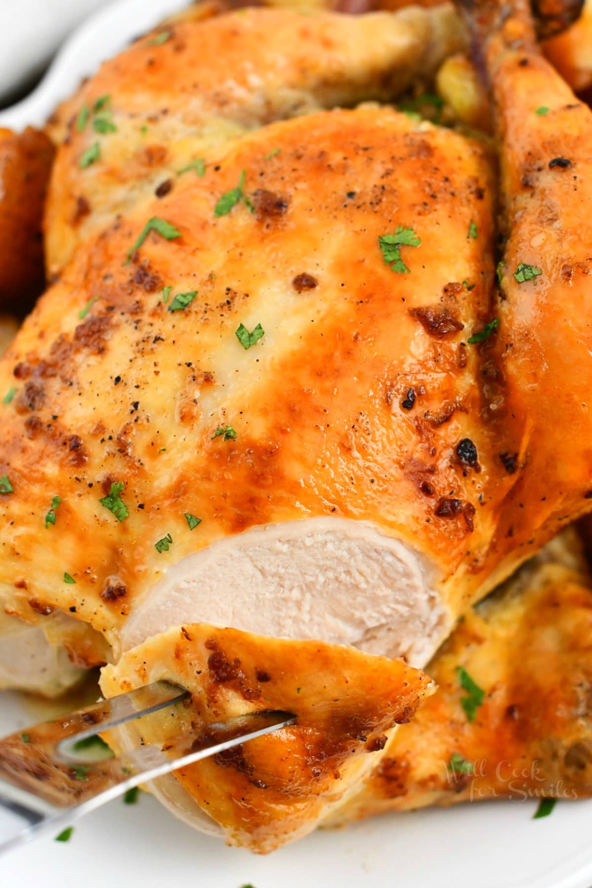 close up photo: carving crispy skinned whole chicken