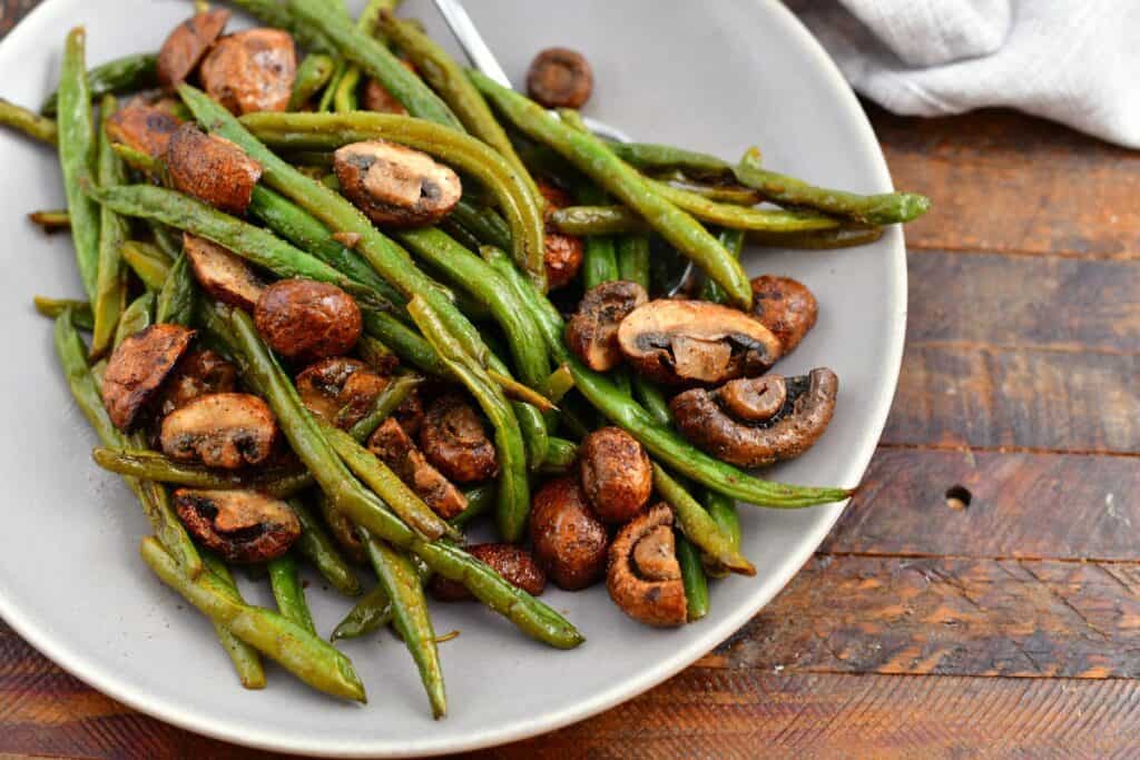 overhead: fresh vegetable side dish in white bowl (green beans and mushrooms)