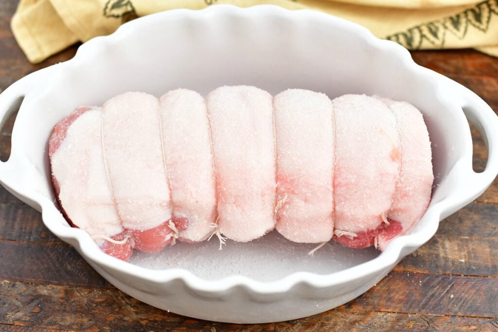 uncooked pork loin roast in white baking dish