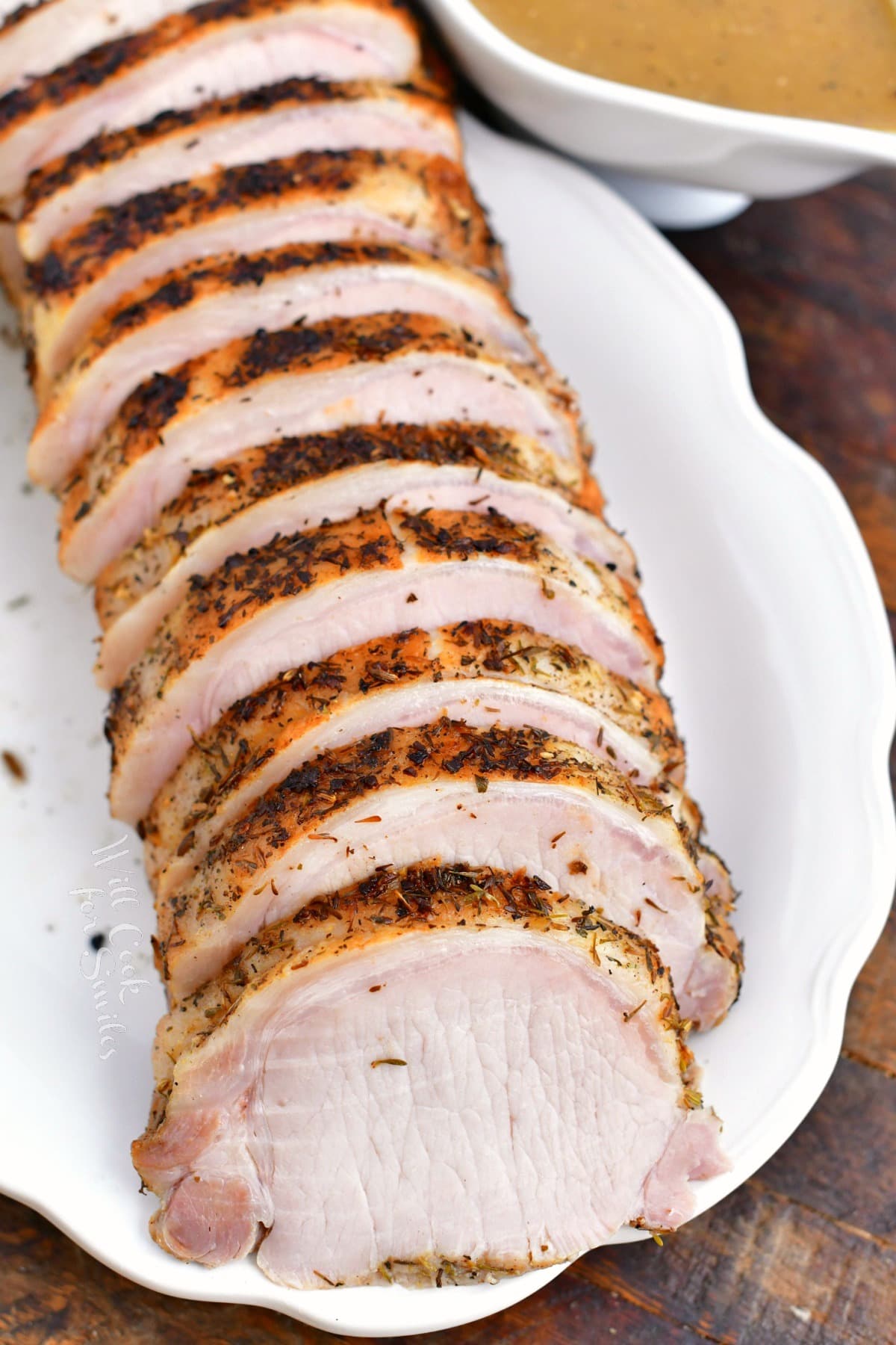 white platter of baked pork loin, cut into slices