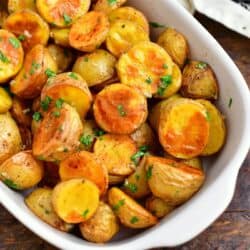 white dish of oven roasted potatoes with parsley and melted butter in white serving dish