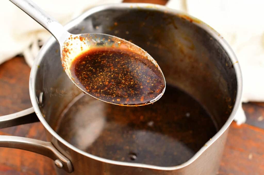 bourbon glaze for ham on spoon above saucepan