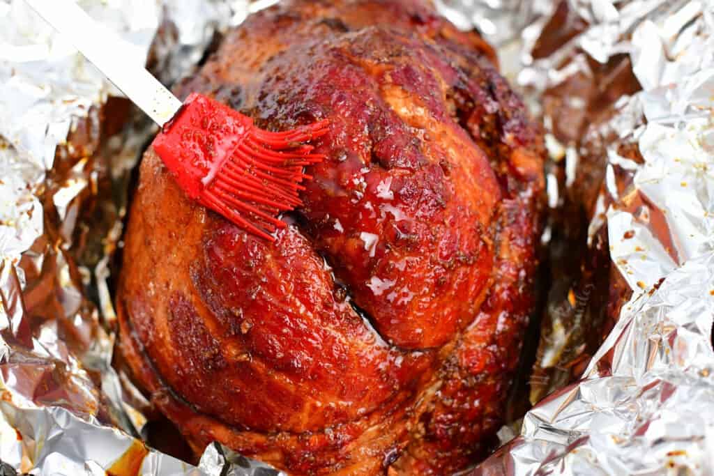 brushing glaze onto ham as it bakes