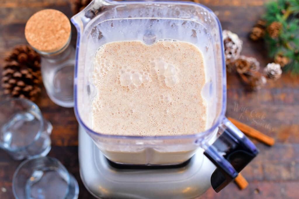 overhead photo: coconut milk, condensed milk, cinnamon and nutmeg in a blender