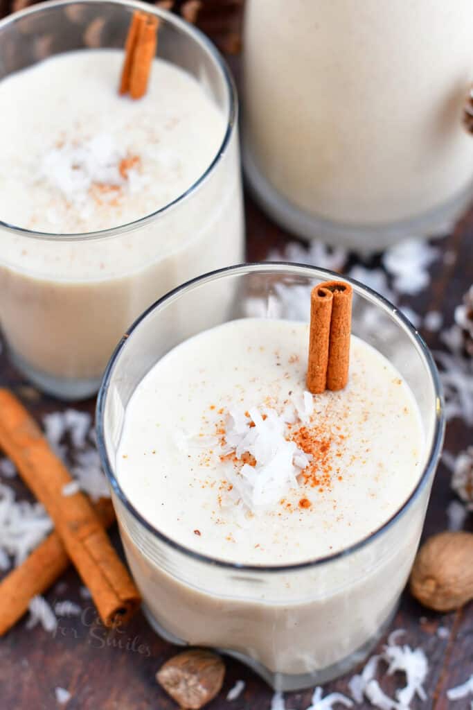 Puerto Rican Christmas drink in 2 glasses with cinnamon sticks and coconut garnish