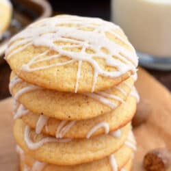 Eggnog cookies are stacked on top of an orange napkin.