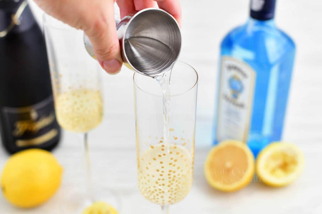 Gin is poured into a champagne glass.