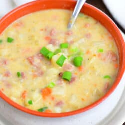 spoon in bowl of creamy potato soup with ham
