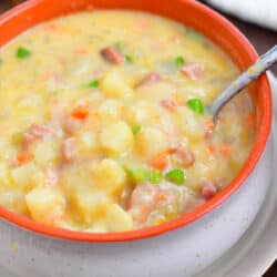 overhead image: spoon in orange bowl of creamy ham chowder