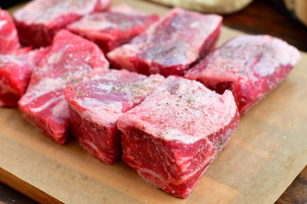 Uncooked beef ribs on a wooden cutting board