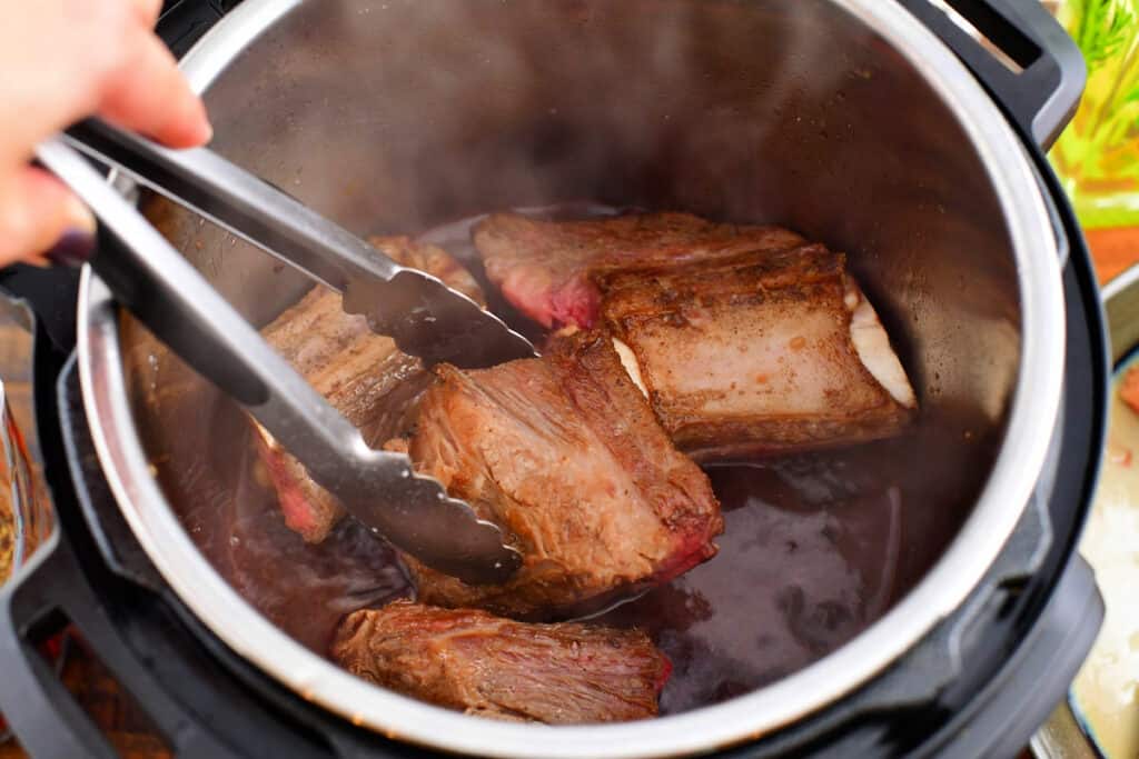 Meat is placed in a red wine mixture in the Instant Pot