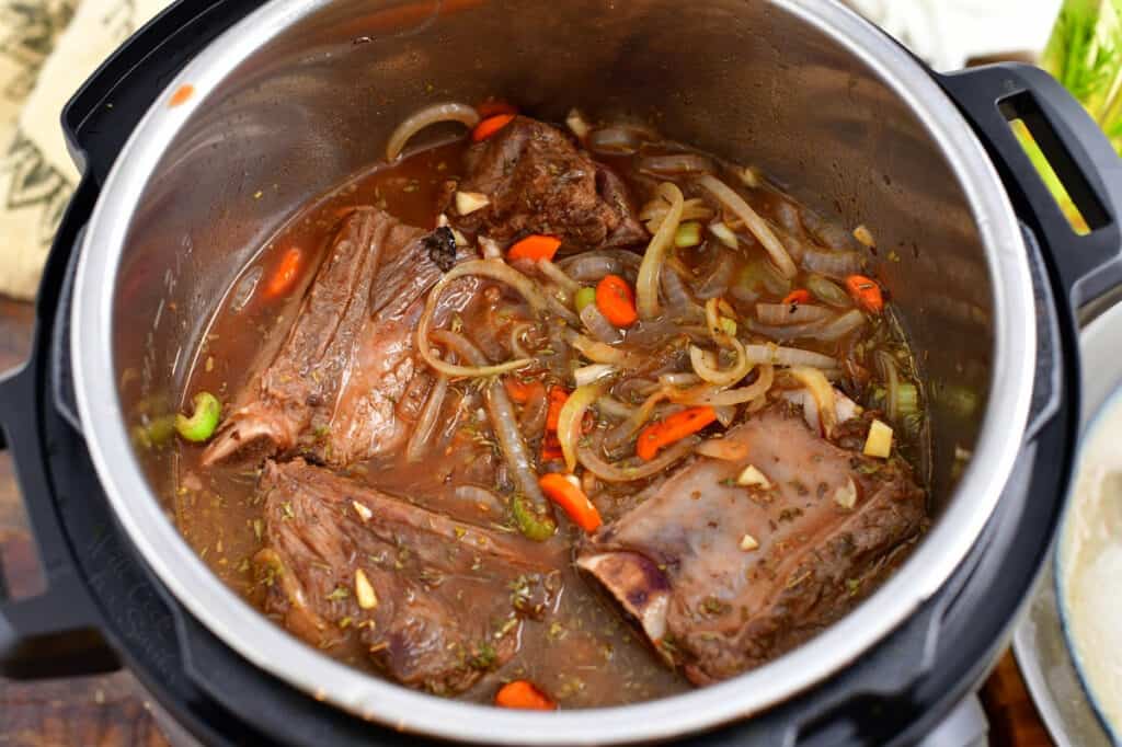 beef ribs and vegetables are fully cooked in a pot.