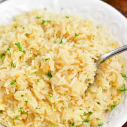 overhead image: spoonful of cooked oven pilaf on spoon in white serving bowl