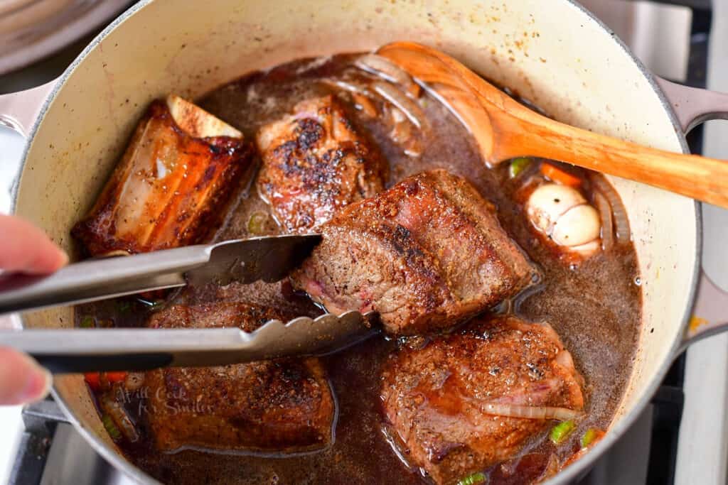 braised short ribs cooking in large pot on stove top