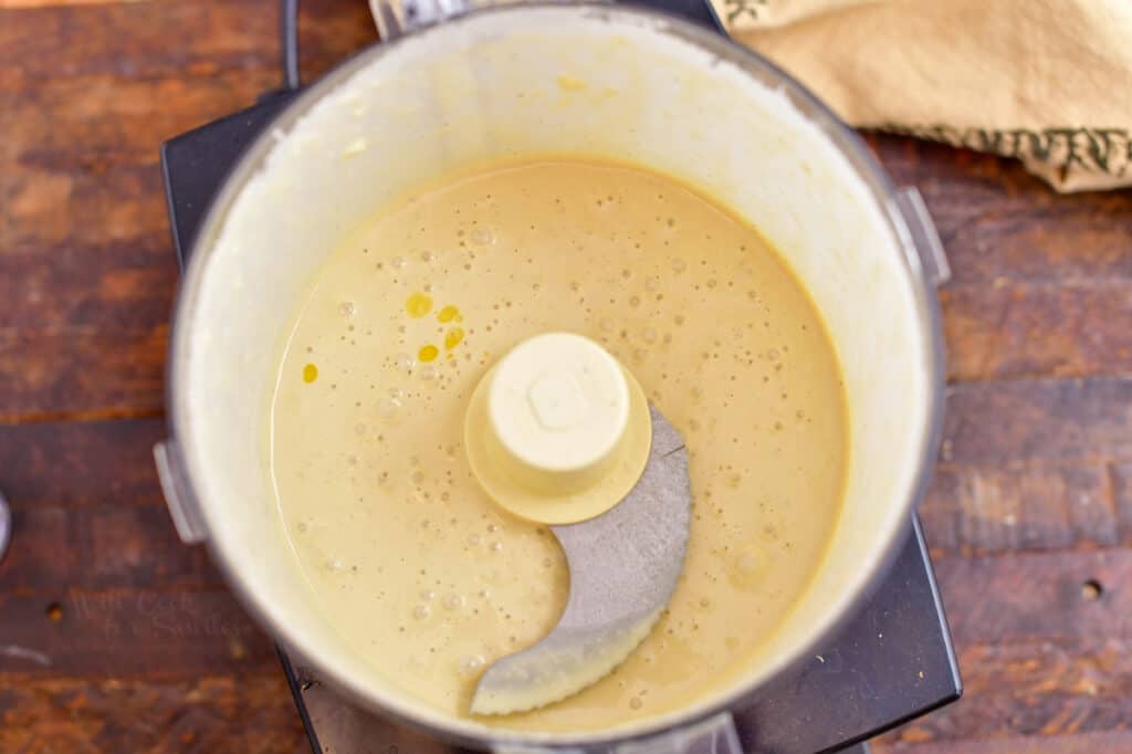 homemade caesar salad dressing in bowl of food processor