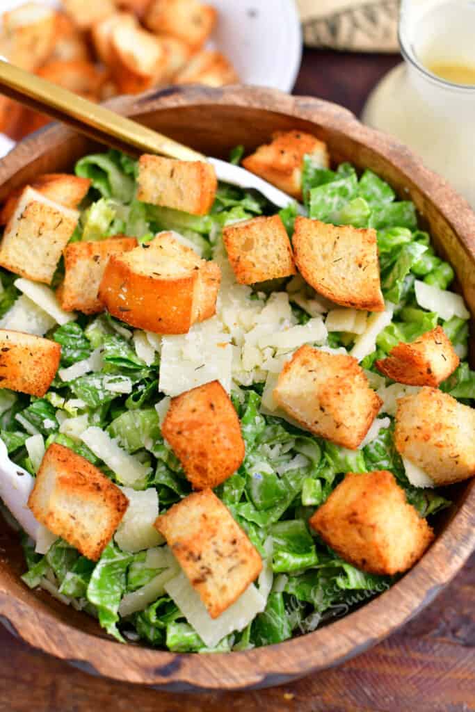 overhead image: wooden bowl of green salad with homemade croutons
