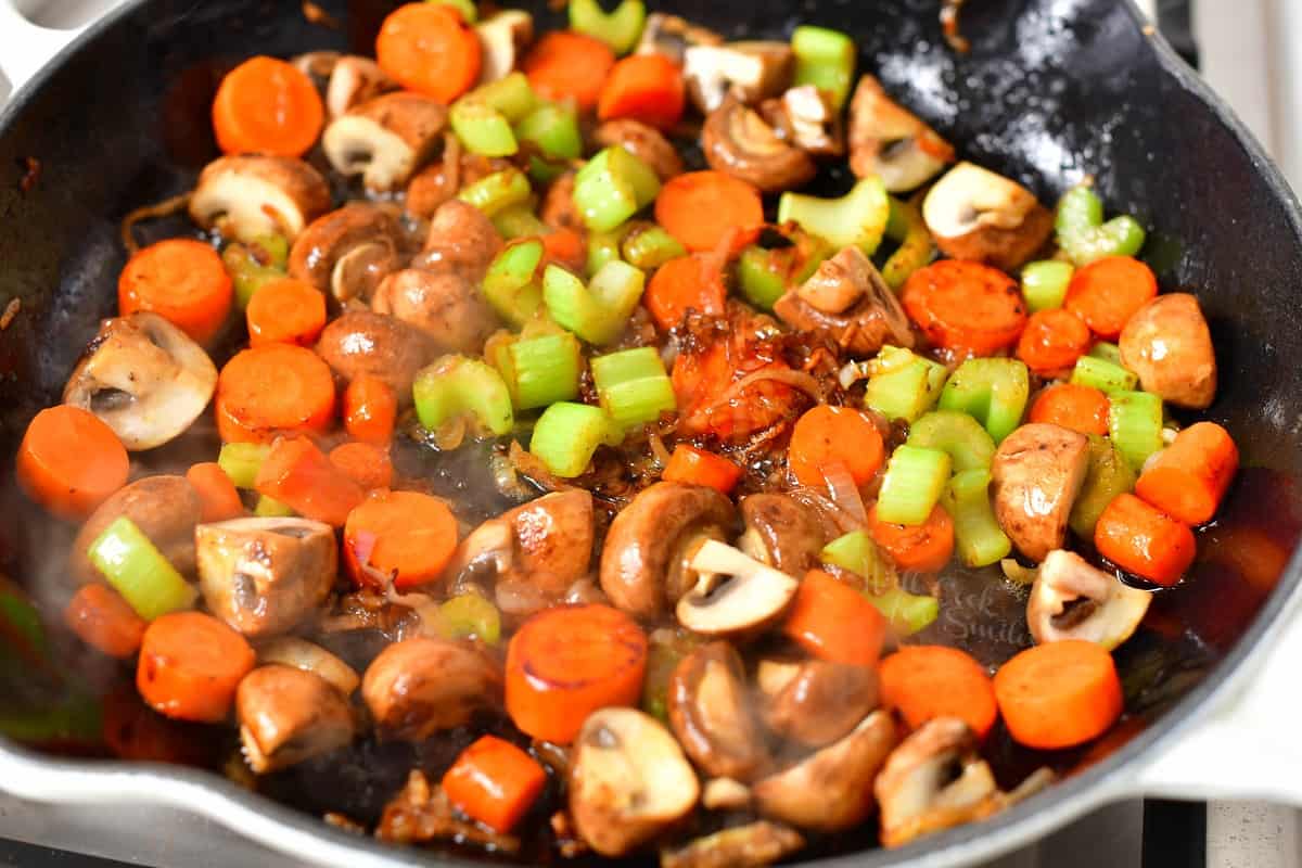 mushrooms, celery, carrot, and shallot cooking in pan of melted butter