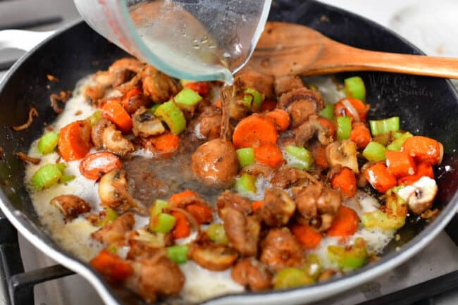 adding white wine to skillet of cooked vegetables for fricassee recipe
