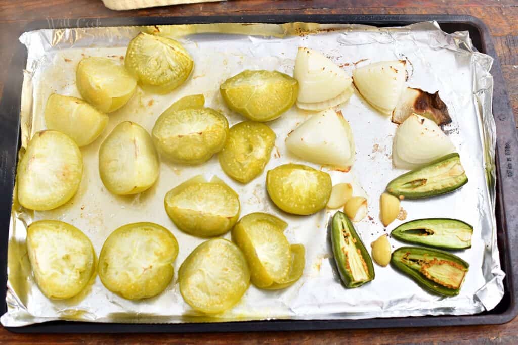 foil lined baking sheet with roasted onions, jalapenos, and tomatillos