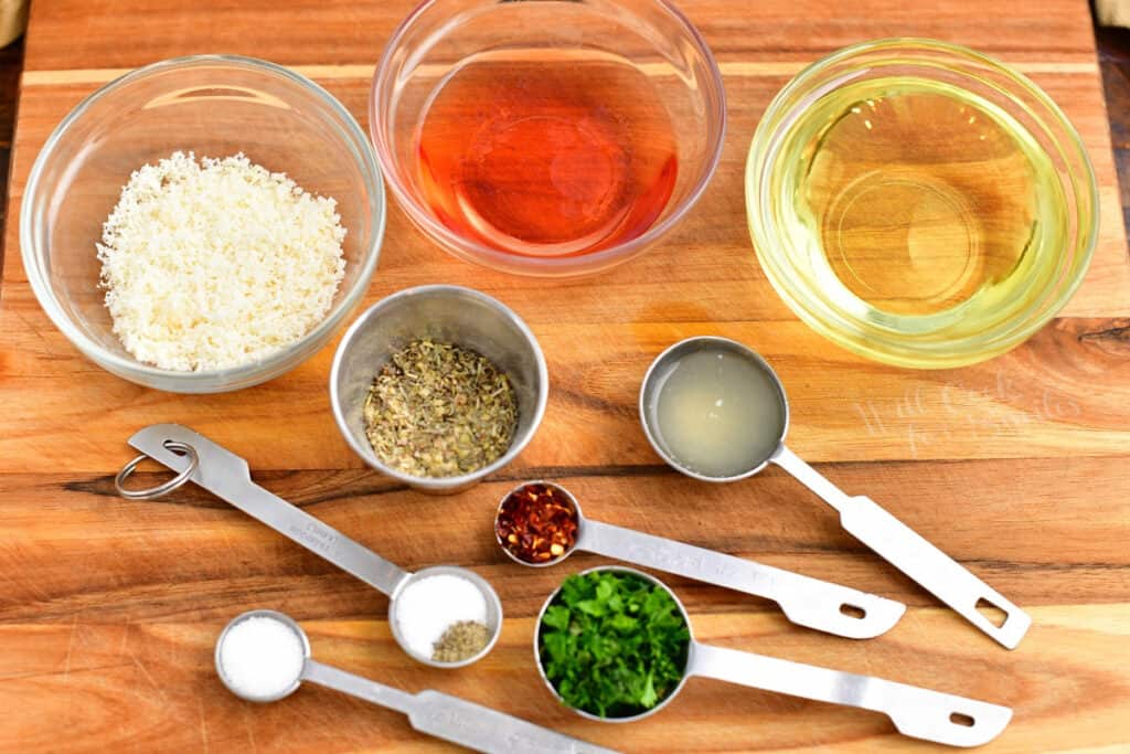 Ingredients in measuring spoons and prep cups to make oil and vinegar dressing recipe