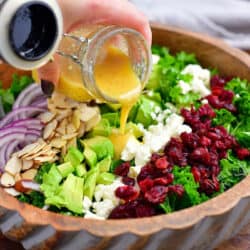 pouring salad dressing over healthy vegetables salad