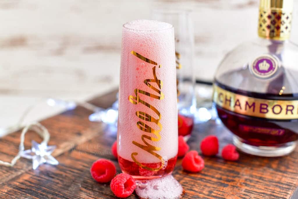 Kir Royale champagne cocktail bubbling over the top of a glass