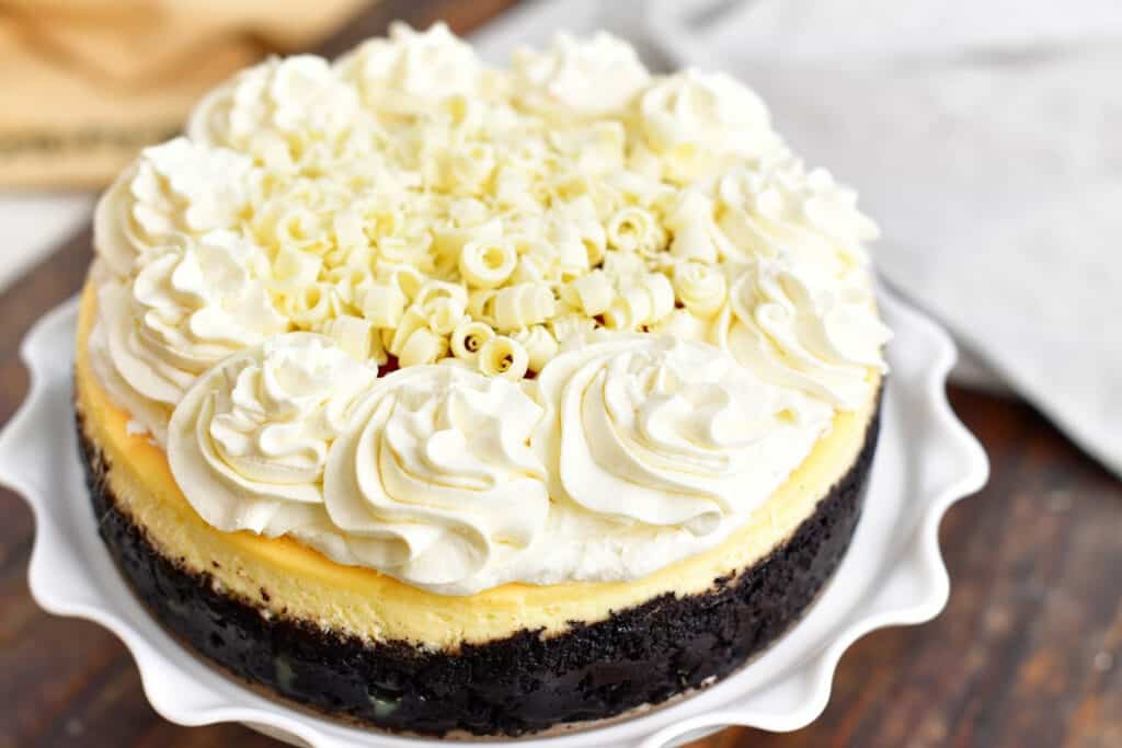 closeup: whole decorated cheesecake on a white cake stand