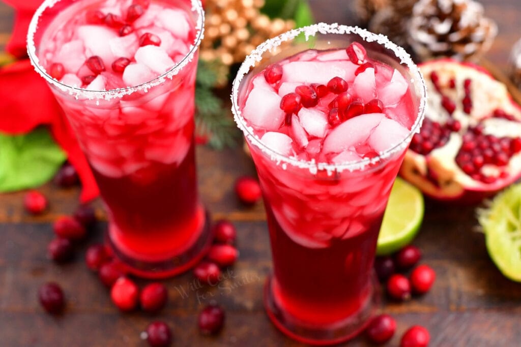 Two full glasses side by side filled with bright red margarita cocktail