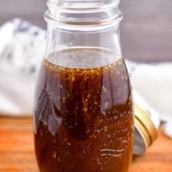 open glass jar of balsamic dressing on a wooden surface