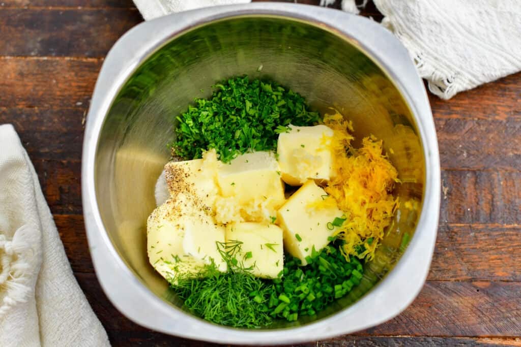 cubes of butter and finely chopped herbs in mixing bowl