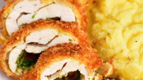 stuffed chicken breast cut into thin slices revealing herb butter inside