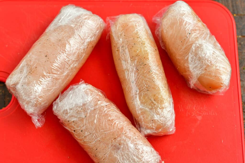 chicken cutlets rolled into cylinder shape, wrapped in plastic wrap