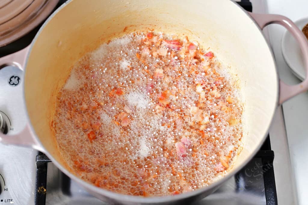 overhead: chopped bacon crisping in a dutch oven