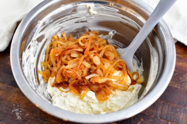 stirring caramelized onions into other onion dip recipe ingredients