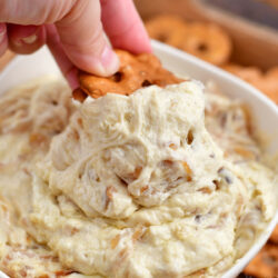 pretzel chip being dipped into a bowl of French onion dip