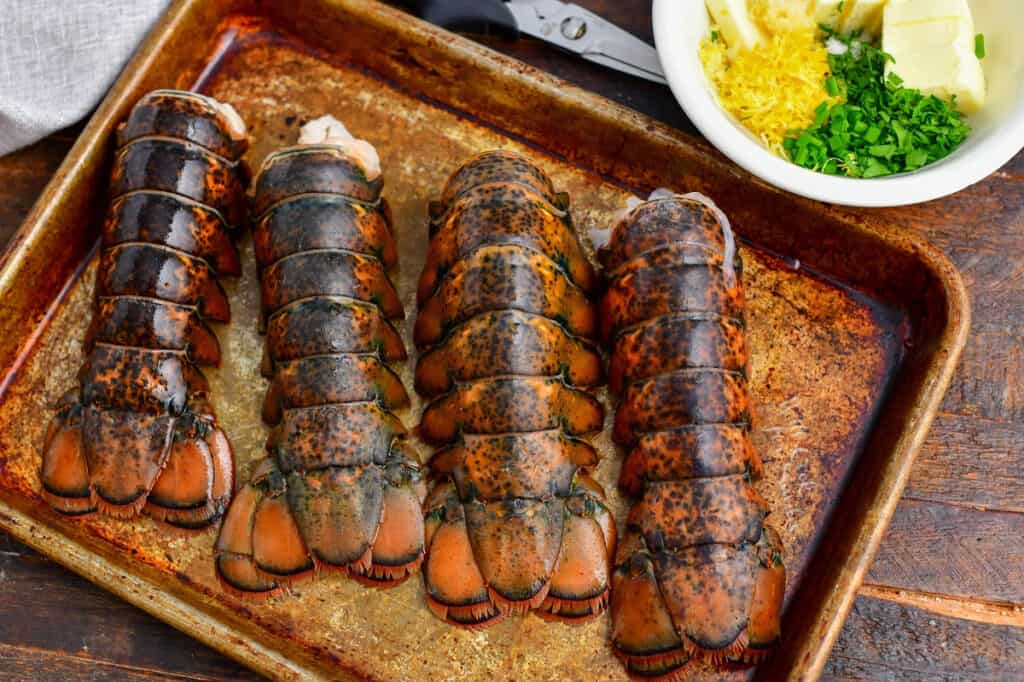 4 lobster tails on metal baking sheet
