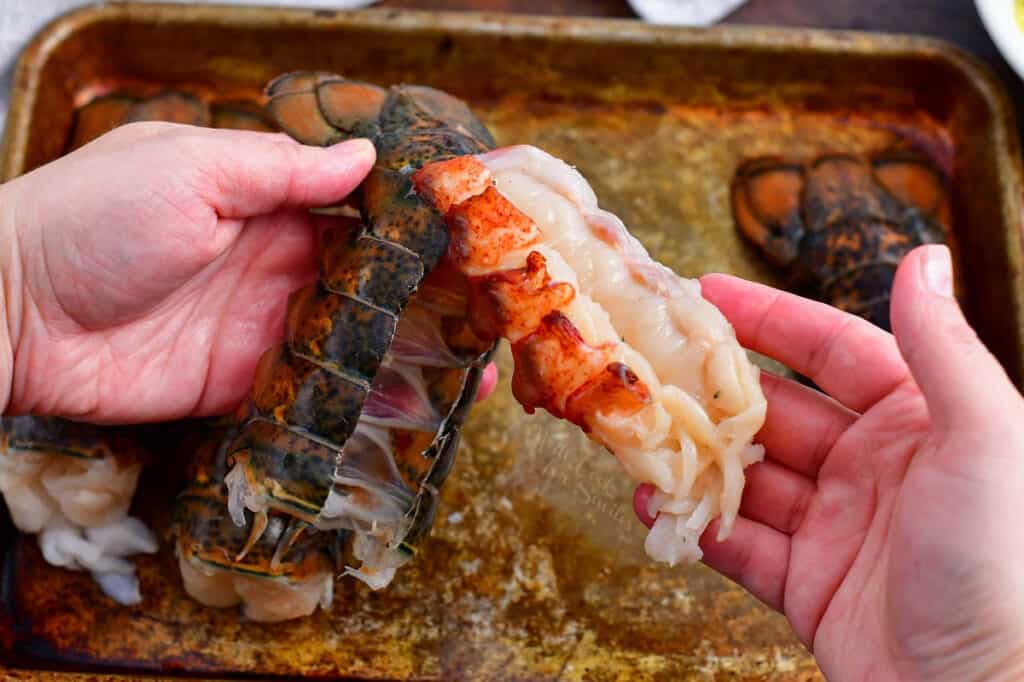 woman's hands removing seafood from the shell