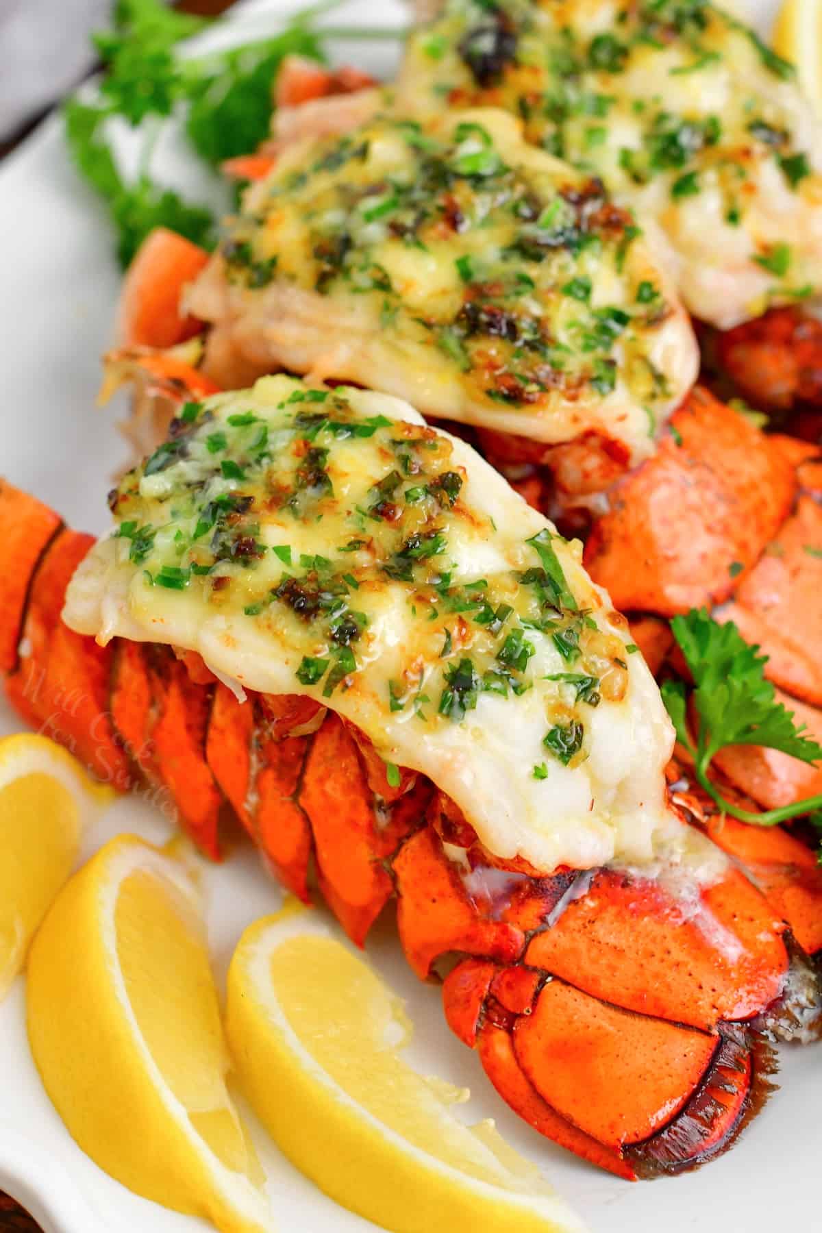 baked lobster tails topped with fresh parsley and herb butter