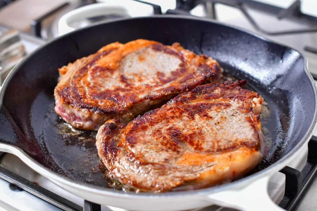 seared ribeye steaks in a skillet