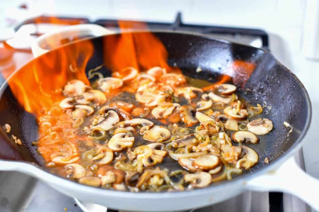 mushrooms flambe in hot skillet
